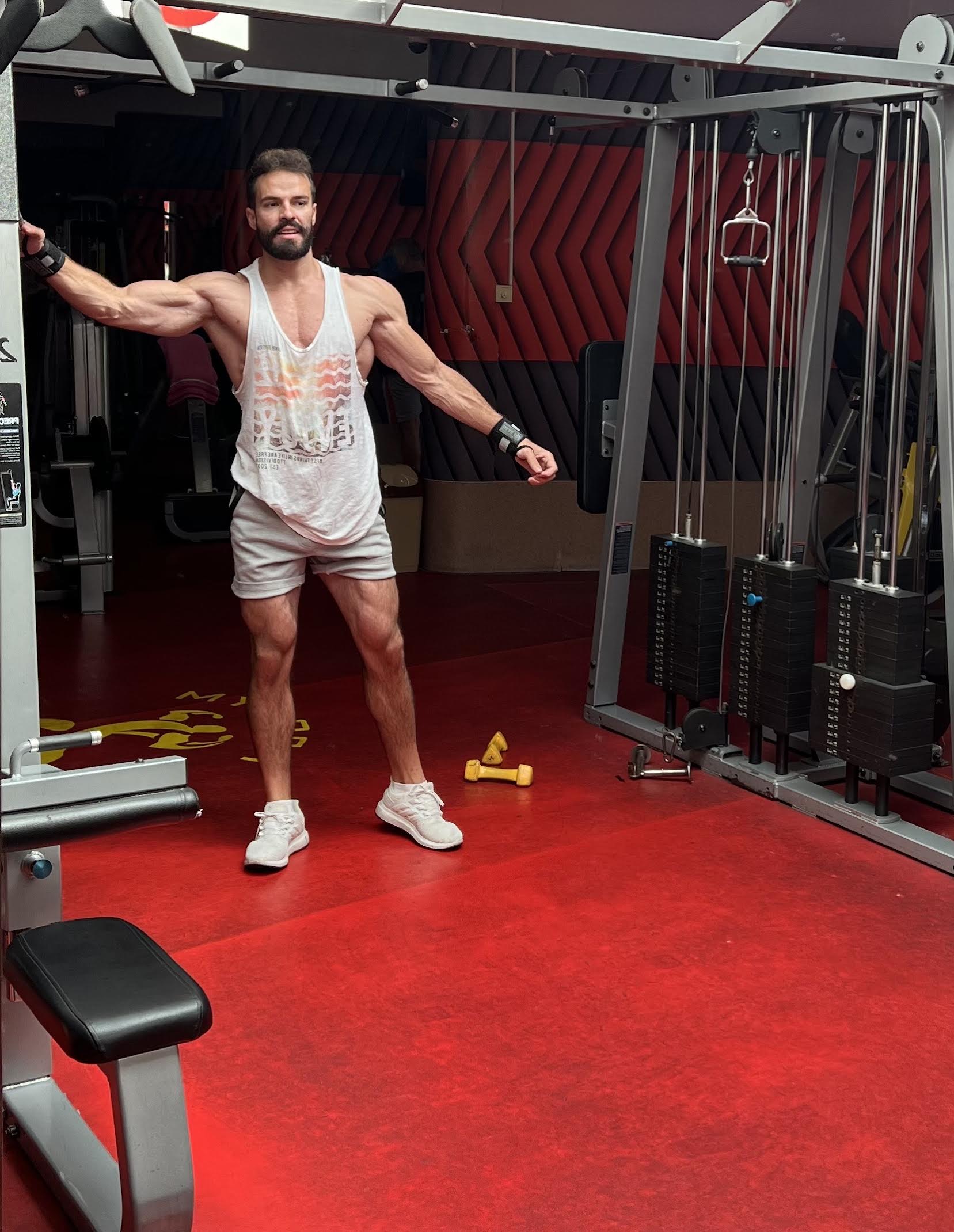 Personal trainer doing cable crossover exercise in the gym