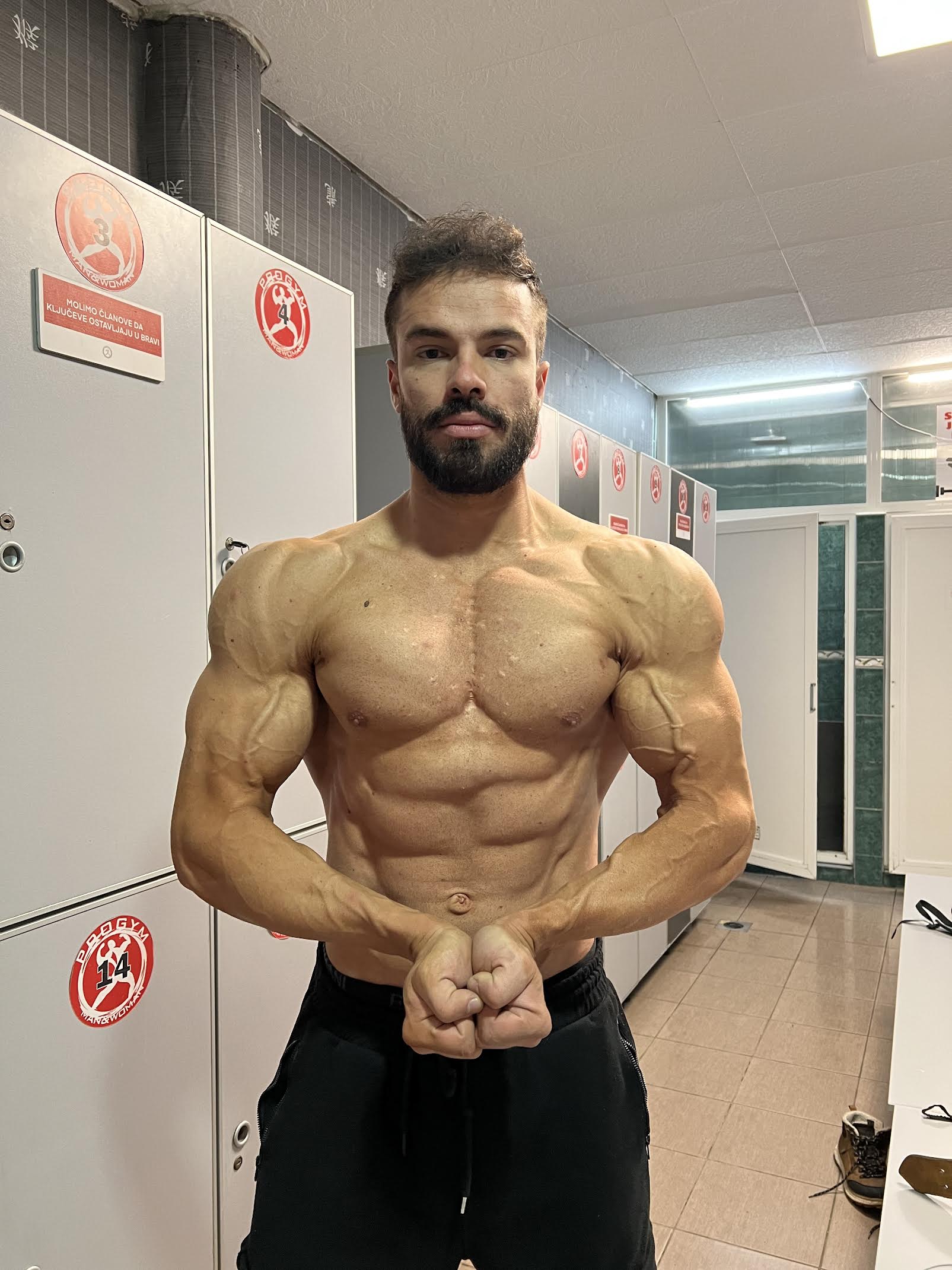 Fitness trainer showing physique results from dedicated training program